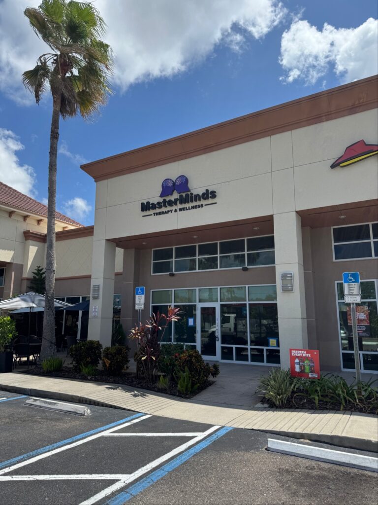 Exterior view of the Masterminds Therapy & Wellness storefront in a shopping plaza, next to a Pizza Hut.